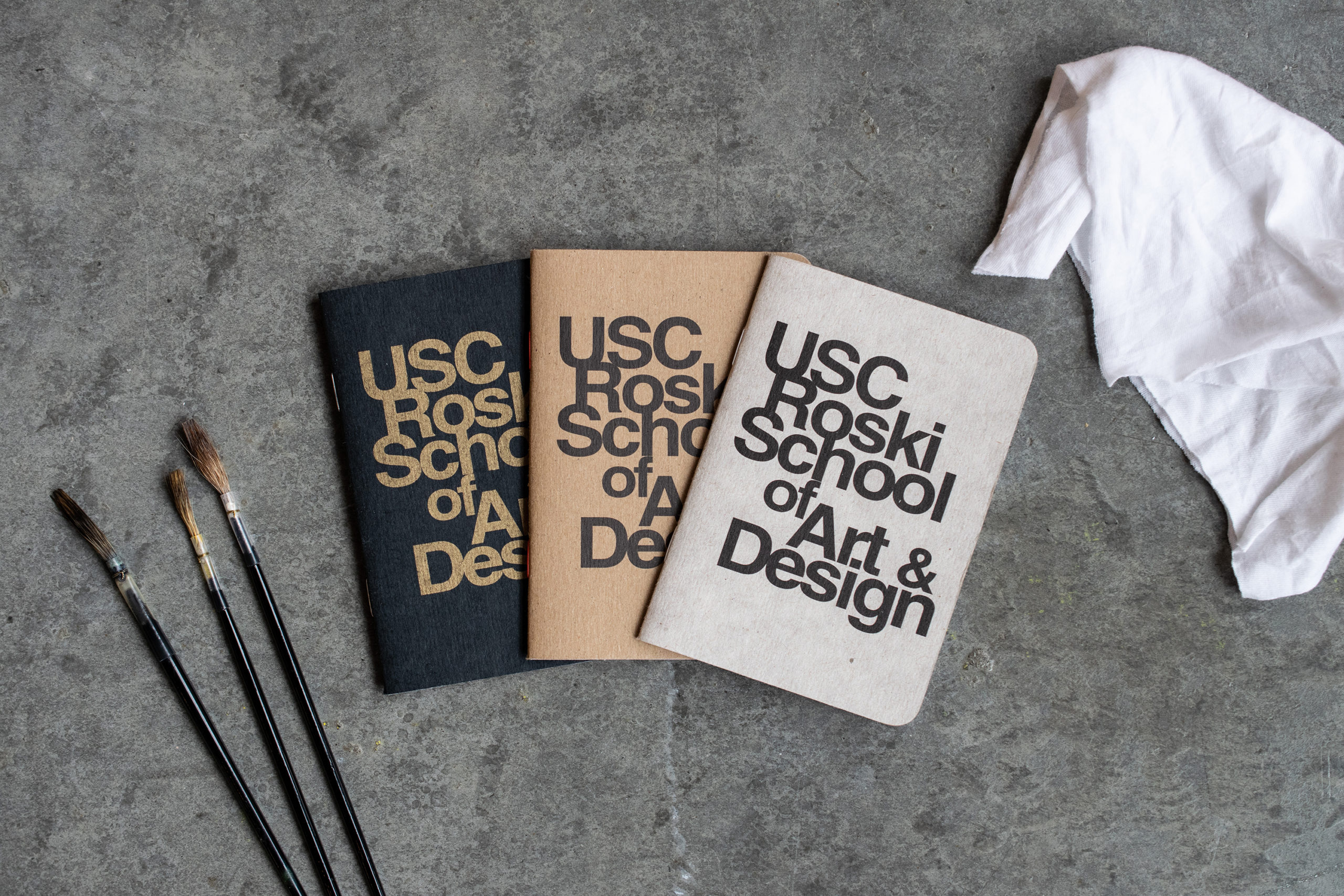 Three books with the logo of USC Roski School of Art and Design printed on their cover.