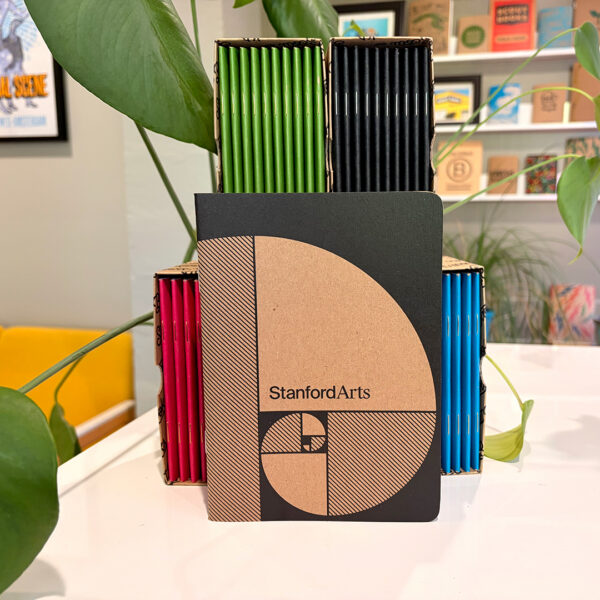 Stanford Arts Scout Book in front of Colorful notebooks